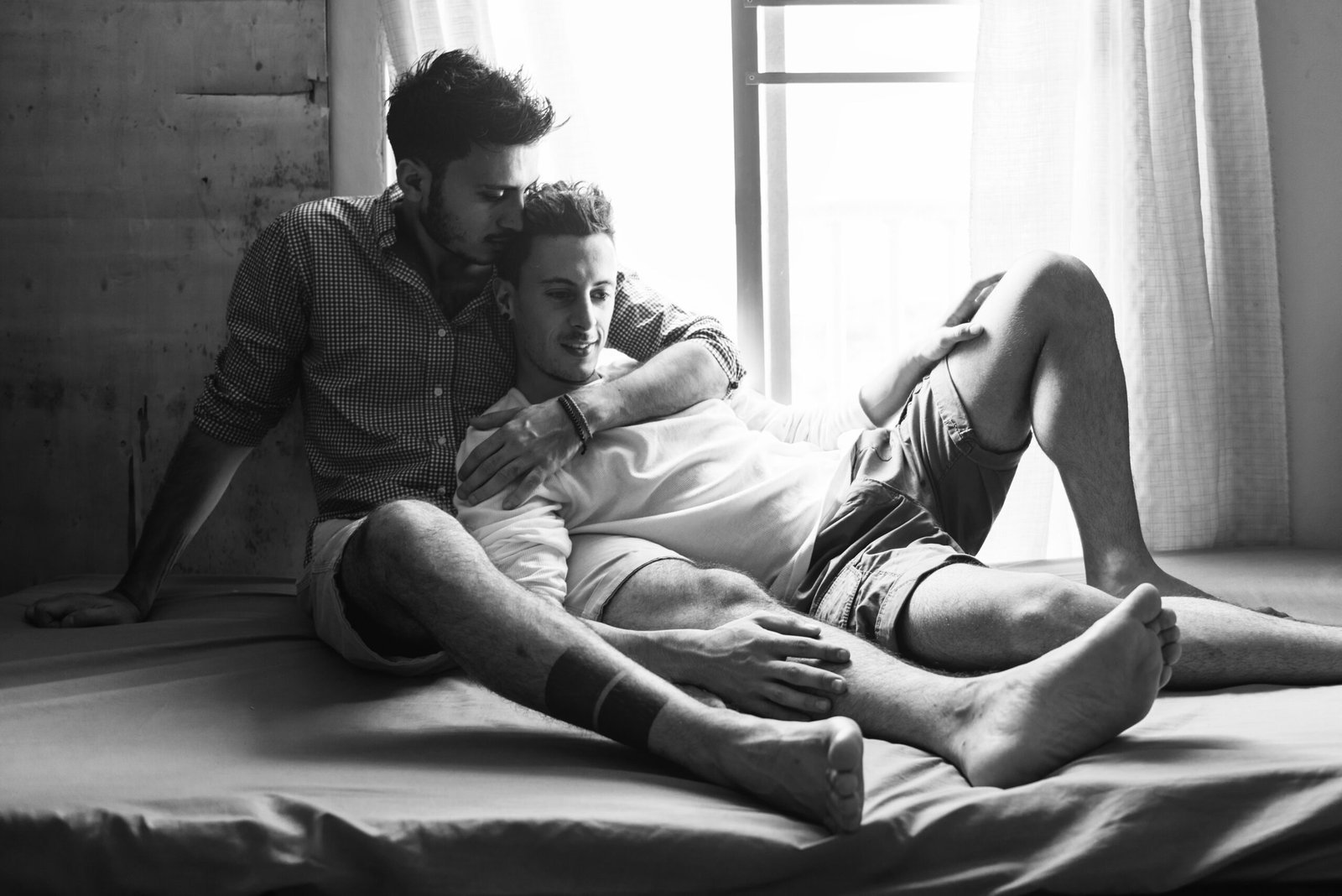 Two men sharing a quiet, intimate moment at home.